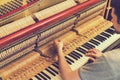 Piano tuning process. closeup of hand and tools of tuner working on grand piano. Detailed view of Upright Piano during a