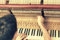 Piano tuning process. closeup of hand and tools of tuner working on grand piano. Detailed view of Upright Piano during a Royalty Free Stock Photo