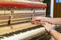 Piano tuning process. closeup of hand and tools of tuner working on grand piano. Detailed view of Upright Piano during a tuning. Royalty Free Stock Photo