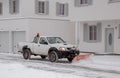 26.01.2021. Piaseczno. Poland. A pickup truck equipped with a plow is removing snow from a sloped driveway in winter. White pickup Royalty Free Stock Photo