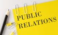 PIBLIC RELATIONS word on the yellow paper with office tools on the white background Royalty Free Stock Photo