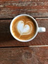 Piccolo coffee with heart latte art on rustic wood table