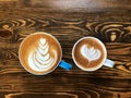 Piccolo latte art coffee cup and cappuccino cup on the wooden table. Choose your cup. Royalty Free Stock Photo