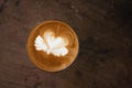 Piccolo Latte art in paper cup on wooden desk