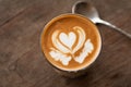 Piccolo Latte art in small glass on wooden table