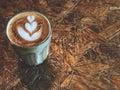 Piccolo latte. heart latte art coffee in Glass on the vintage wooden table.