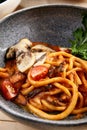 Pichi with mushrooms and creamy tomato allione in gray bowl