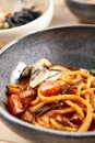 Pichi with mushrooms and creamy tomato allione in gray bowl