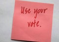 Handwritten red letters on plain background `Use your vote`