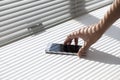 Pick up SmartPhone on table with Sunlight entering the window