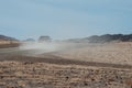 Pick up truck driving in the dry desert road and making dust. Royalty Free Stock Photo