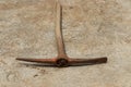 Pickaxe with sharp blades and wooden handle laid in ground