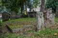 Old moss and ivy covered tomb grave in churchyard with gravestones