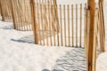 Picket fence on white sand beach. Royalty Free Stock Photo