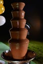 Picking fruit skewer stick into chocolate fountain fondue placed on a table in hotel restaurant Royalty Free Stock Photo