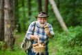 Picking mushrooms. Happy Grandfather with mushrooms in busket hunting mushroom. Mushrooming in nature.