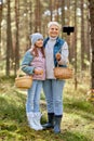 Grandma with granddaughter taking selfie in forest Royalty Free Stock Photo