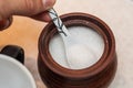 Picking sugar from a sugar bowl with a small ceramic spoon Royalty Free Stock Photo