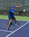 Pickleball Action - Man Wearing Blue Gritting Teeth While Stretching To Hit Forehand Shot