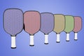 Pickleball multicolored rackets lined up in a row on an isolated background. 3D rendering