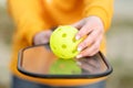 Pickleball paddle and yellow ball close up, woman playing pickleball game, hitting pickleball yellow ball with paddle