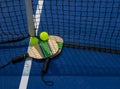 Pickleball paddles and whiffle balls on a court by the net close up