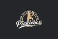 pickleball vector graphic with a combination of a pickleball player, circle, and lettering in emblem shape and vintage style.