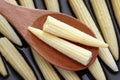 Pickled baby corn in a wooden spoon