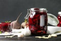 Pickled beets in glass jar on wooden table against background