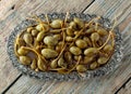 Pickled caper berries in metal dish .