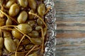 Pickled caper berries in metal dish .