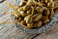 Pickled caper berries in metal dish .