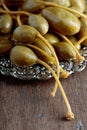 Pickled caper berries in metal dish .