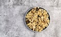 Pickled champignons mushrooms on a round plate on a dark gray background