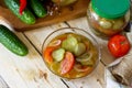 Pickled cucumber salad with tomatoes on the kitchen wooden background. Homemade pickle.