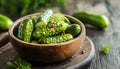 Pickled cucumbers in bowl on wooden rustic board Royalty Free Stock Photo