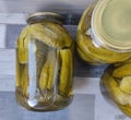 Pickled cucumbers in a glass jar. Three large jars of pickles on the table