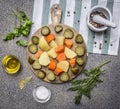 Pickled cucumbers, potatoes, carrots and seasoning with herbs wooden rustic background top view close up