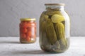 Pickled cucumbers and tomatoes in jars on chalk background Royalty Free Stock Photo