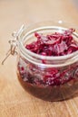 Fermented red cabbage in a glass jar on a wooden table. Healthy vegetarian food with vitamins