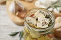Pickled feta cheese in jar on white wooden table Royalty Free Stock Photo