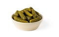 Pickled gherkins in a beige ceramic bowl isolated on a white background. Whole green cornichons marinated with dill, garlic and Royalty Free Stock Photo