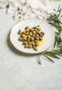 Pickled green Mediterranean olives in olive oil on white plate Royalty Free Stock Photo