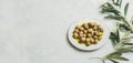 Pickled green Mediterranean olives and olive-tree branch, wide format Royalty Free Stock Photo