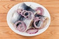 Pickled herring fillets with onion on dish on rustic table Royalty Free Stock Photo