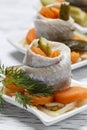 Pickled herring rolls with vegetables on wooden table Royalty Free Stock Photo