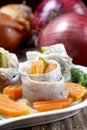 Pickled herring rolls with vegetables on wooden table Royalty Free Stock Photo