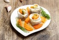 Pickled herring rolls with vegetables on wooden table Royalty Free Stock Photo