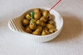 Pickled olives in a bowl on a white table