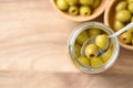 Pickled olives, Pitted green olives in glass jar with spoon Royalty Free Stock Photo